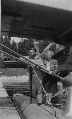 Black and white photo, a man and a woman standing with a bush plane