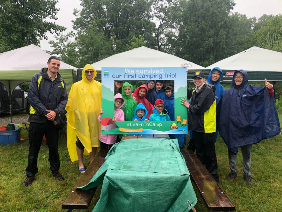 Une photo de groupe avec le cadre du programme Apprendre à camper sous la pluie