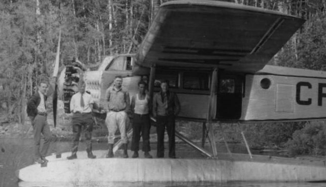 Bush plane with four guys posing (black and white photo)