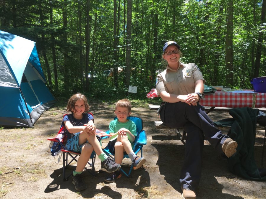 Deux enfants en compagnie de l’animatrice du programme Apprendre à camper sur leur emplacement de camping.<br />Lieu : Le parc provincial Grundy Lake<br />Photo : Le parc provincial Grundy Lake 
