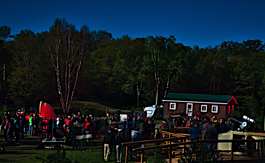 Groupe dans le champ de l’observatoire la nuit sous un ciel étoilé