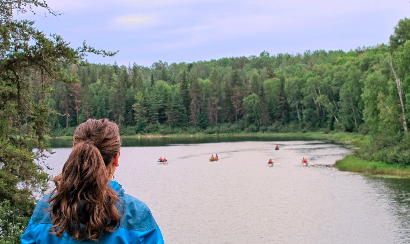 une personne regardant les canots sur le lac
