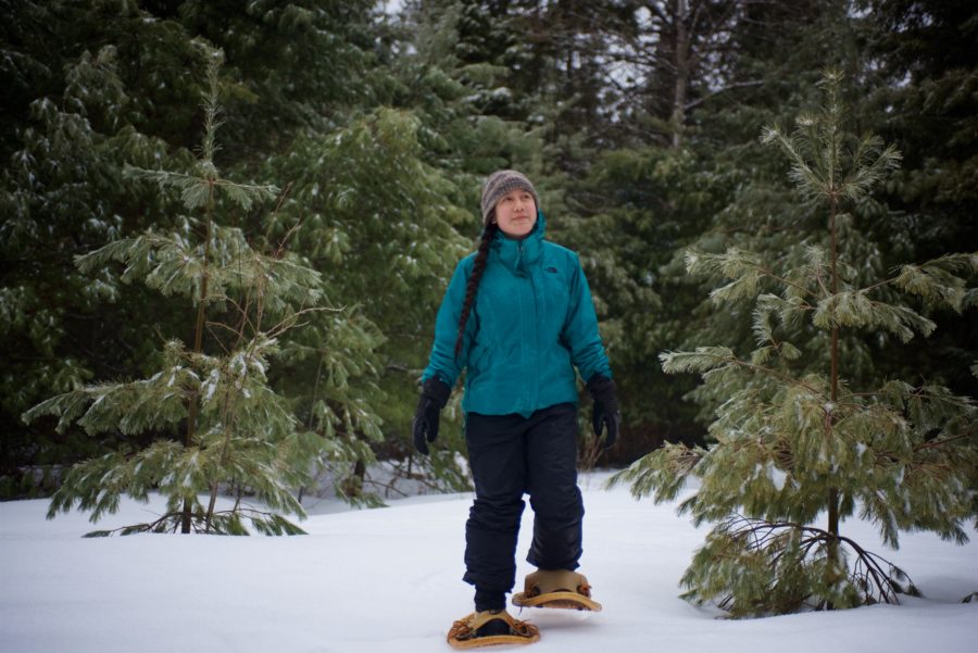 woman snowshoeing near trees