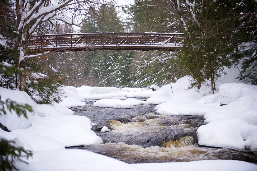 Pont enjambant une rivière en hiver.