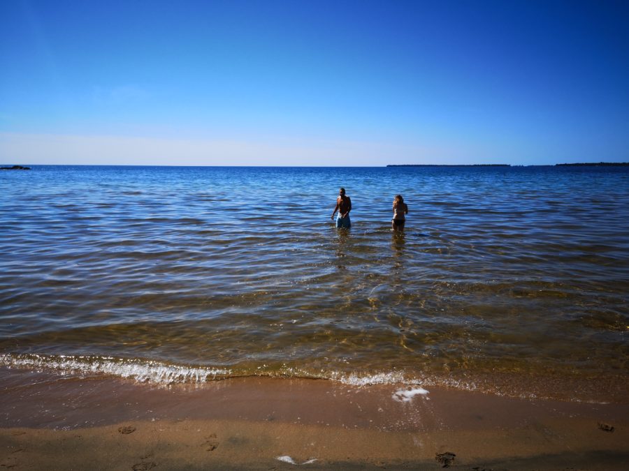 Deux personnes dans l’eau au bord de la plage.