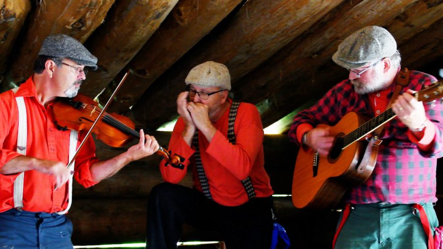 Three members of the Wakami Wailers playing music at Algonquin's logging museum. 