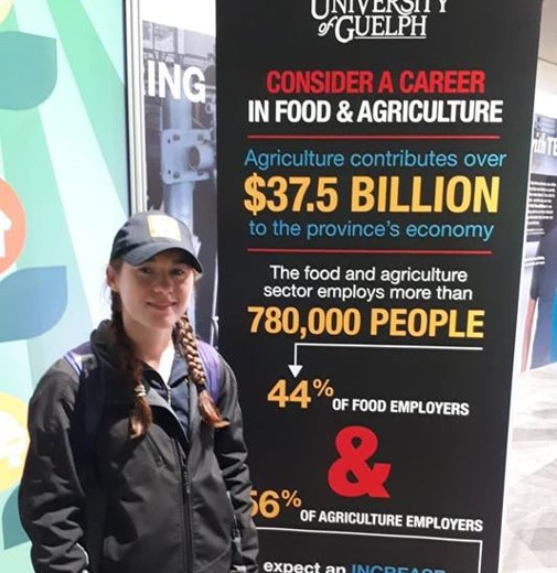 Femme devant une affiche portant sur l’agriculture