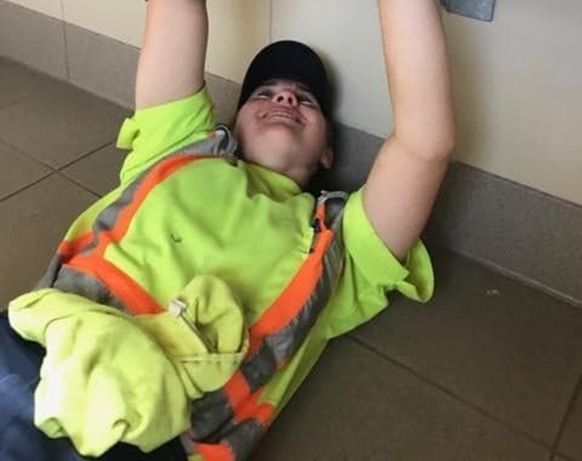 Employée couchée sur le sol réparant la tuyauterie