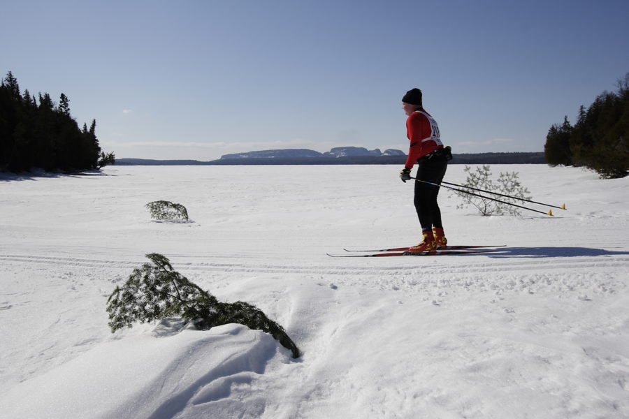 Une personne skiant lors du rallye le long d’un lac gelé