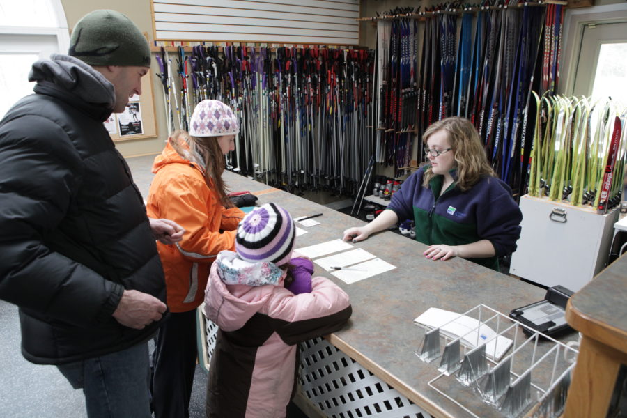 Une famille loue de l’équipement de ski d’une employée de Parcs Ontario.