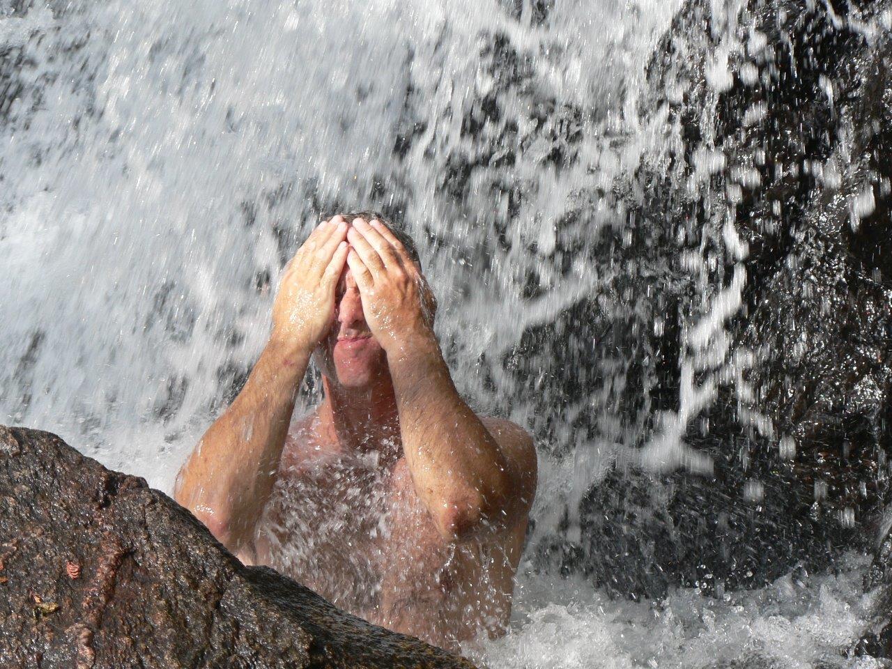person under waterfall