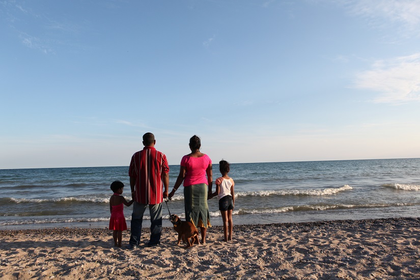 Une famille sur la plage regarde au large