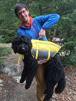 une personne tient un chien avec un dispositif de flottaison
