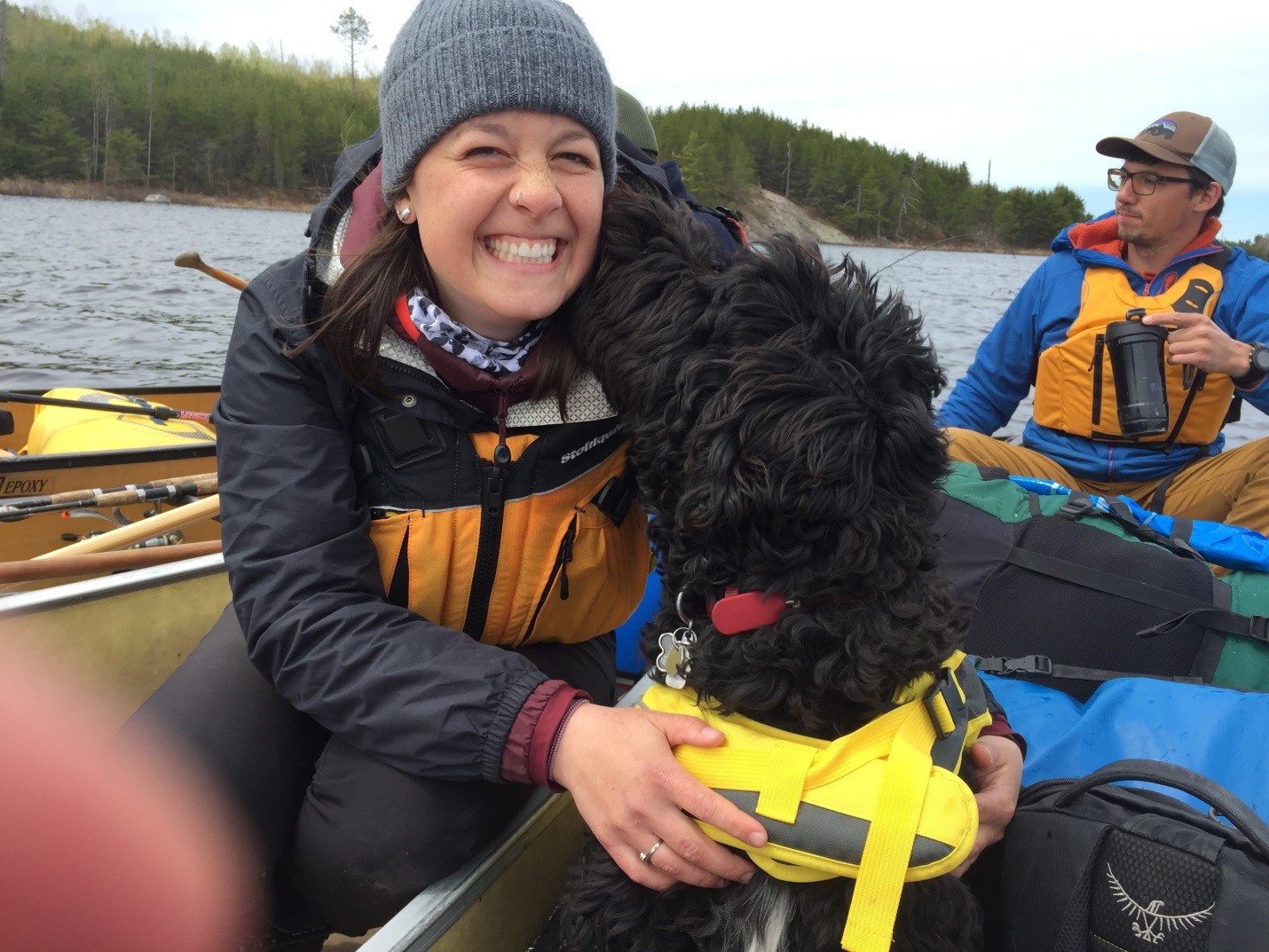 dog with two people in canoe