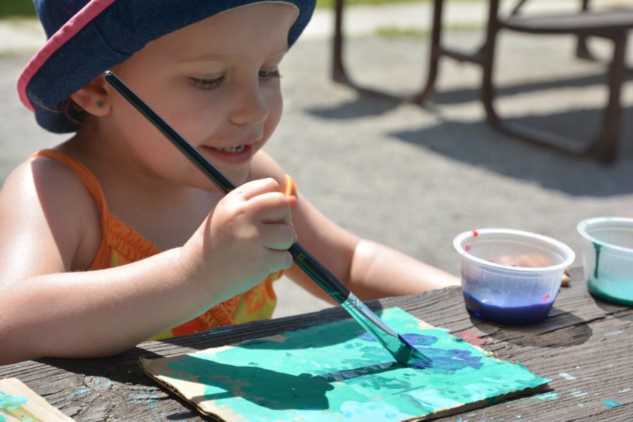 Young camper painting during one of the Art in the Park programs.