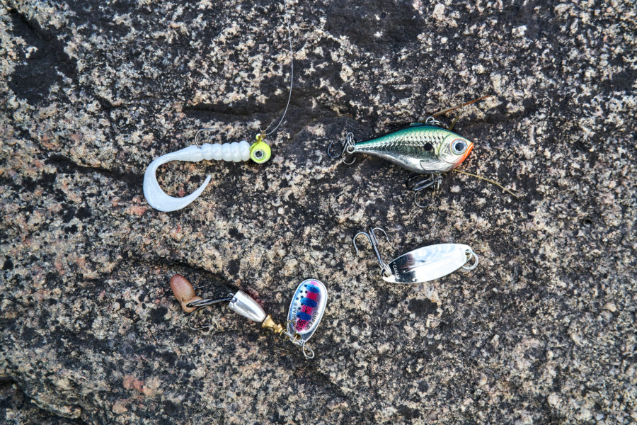 Four different lures sitting on the ground.