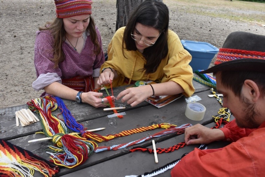 Learning how to weave a sash like the voyageurs