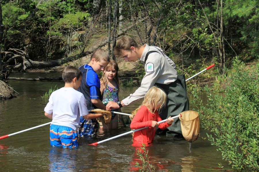 Discovery leader in creek with kids
