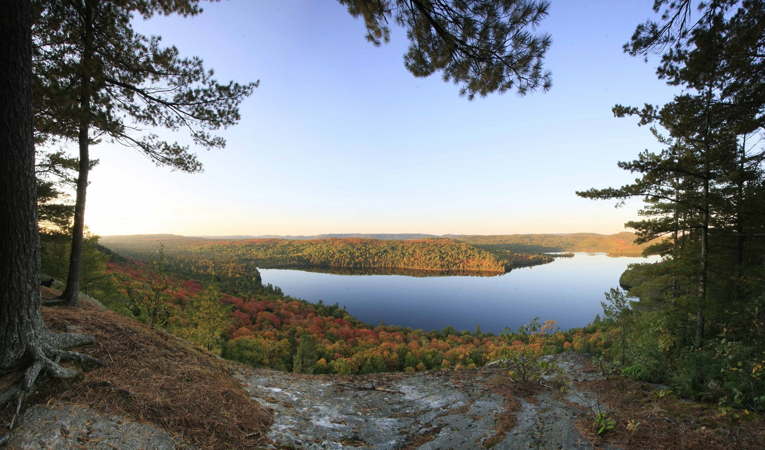 Point de vue en surplomb sur le feuillage d’automne et le lac
