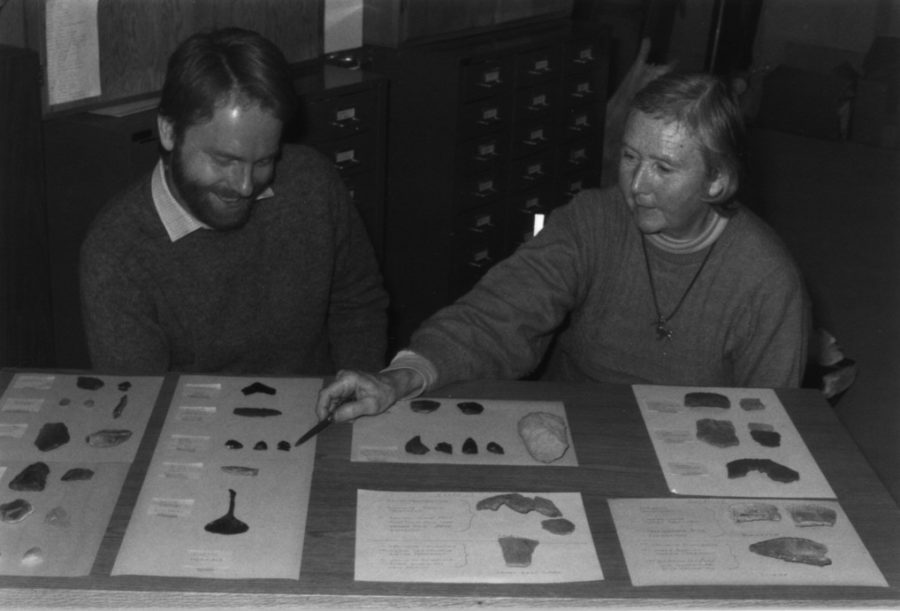 Shirley et David assis devant une table avec plusieurs trouvailles archéologiques. 
