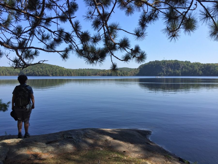 Une femme debout devant un lac calme