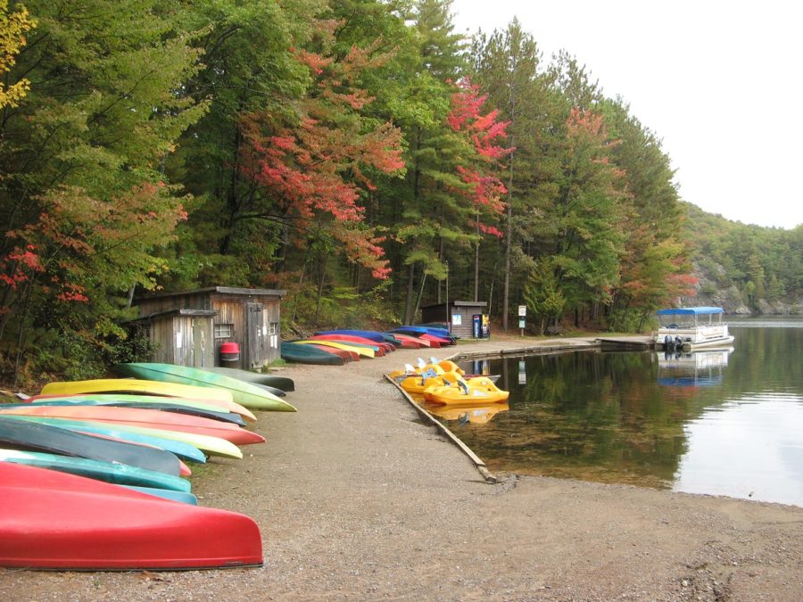 boathouse and canoes with fall foliage beside lake
