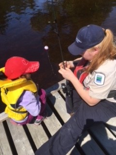 Rebecca en train d’aider des campeurs à pêcher.