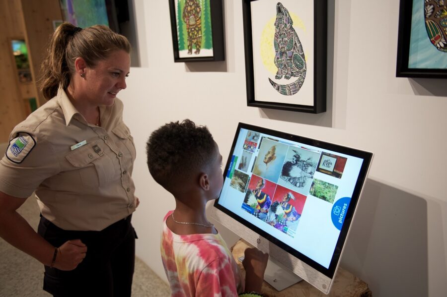 staff member and child using touchscreen