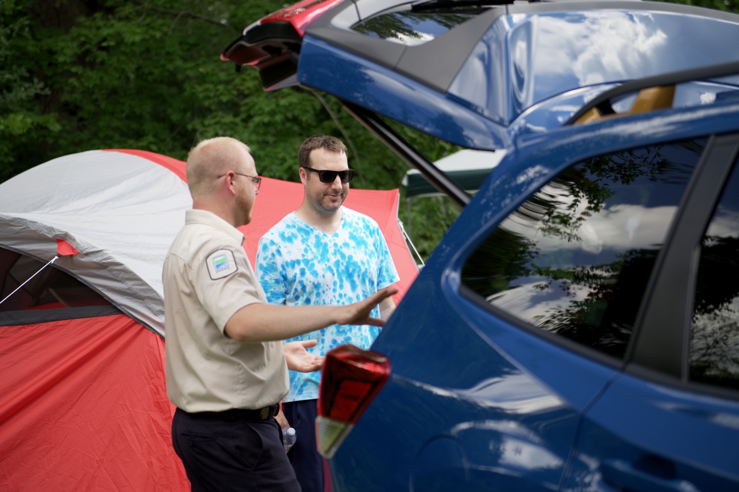 A staff person helping a camper load their car