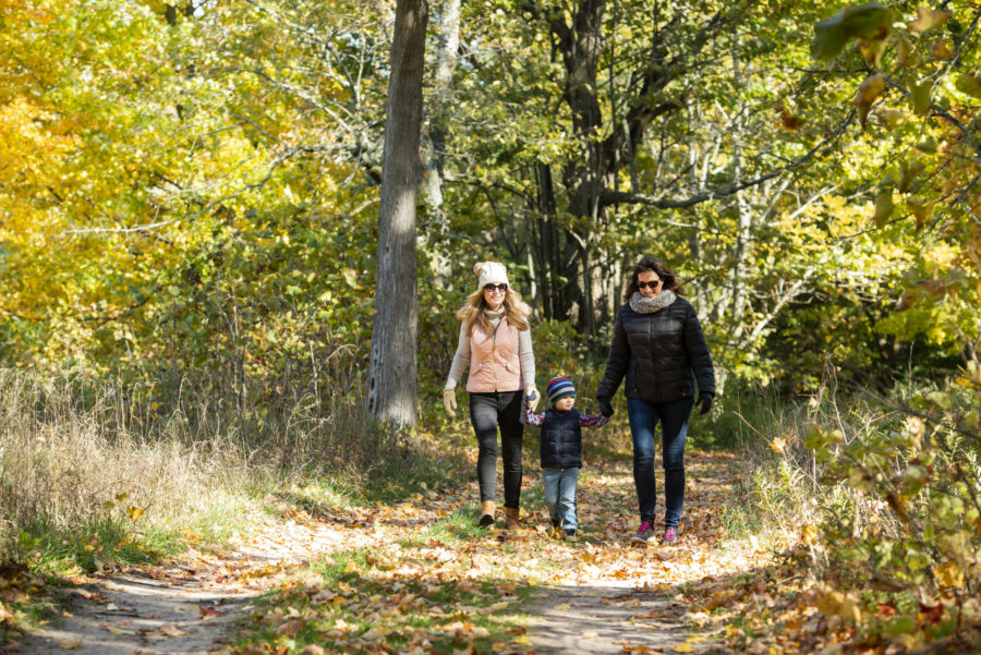 Couple and child walking in the fall at Sandbanks