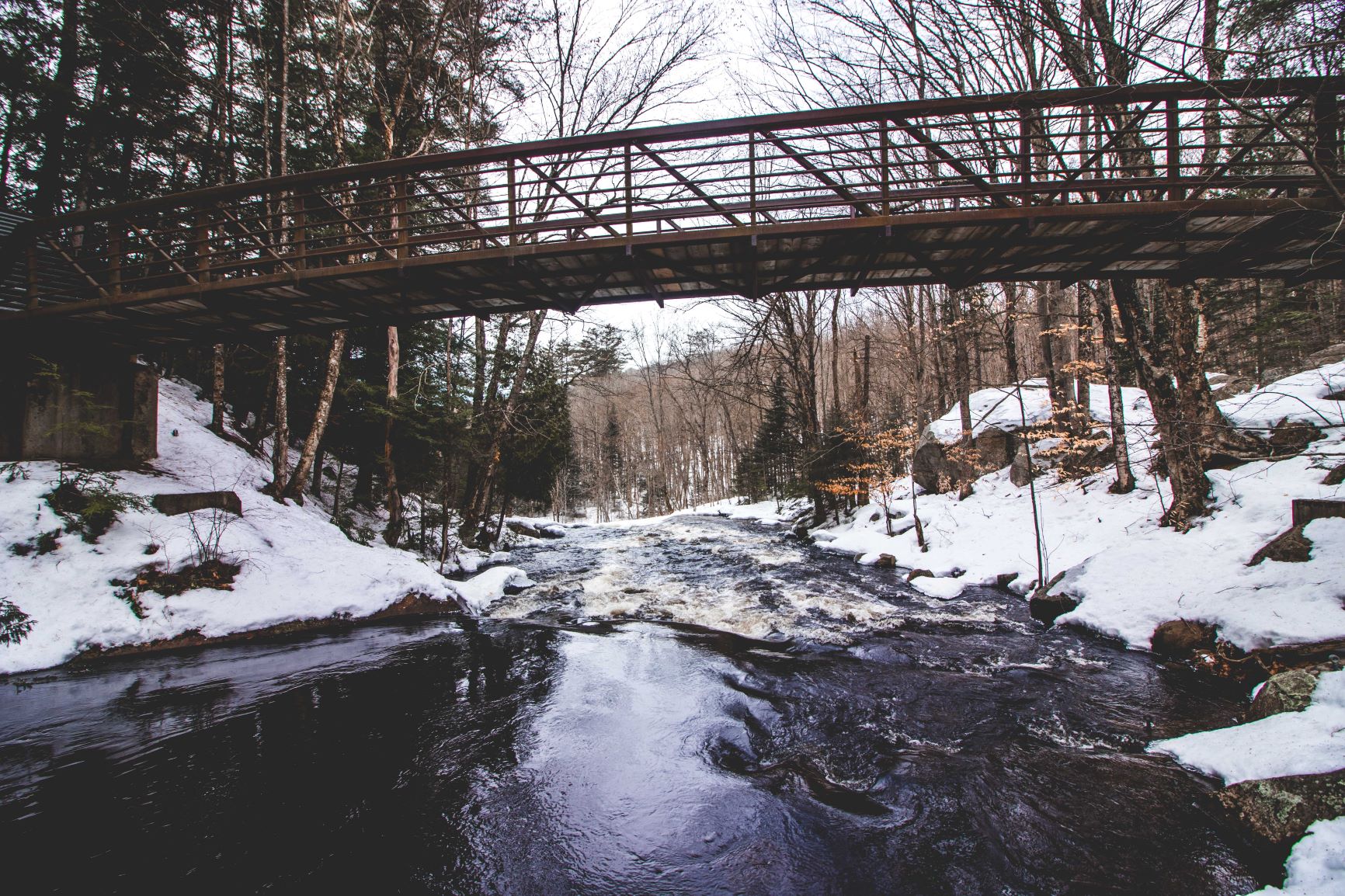 Pont par-dessus un ruisseau enneigé