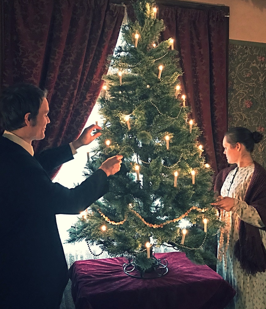 Une famille de l’ère victorienne décorant un arbre de Noël