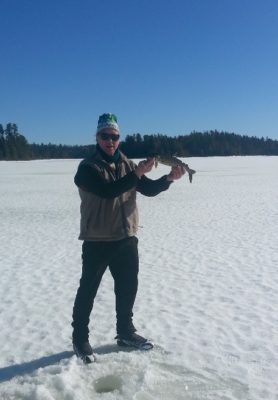 man holding fish on lake