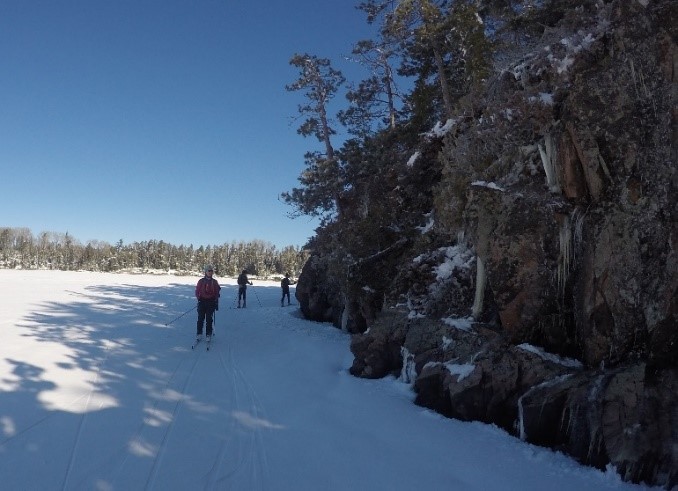 skiers beside cliff at Quetico
