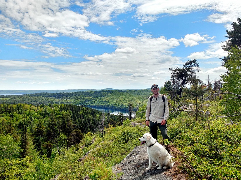 Hiker at a lookout with a dog