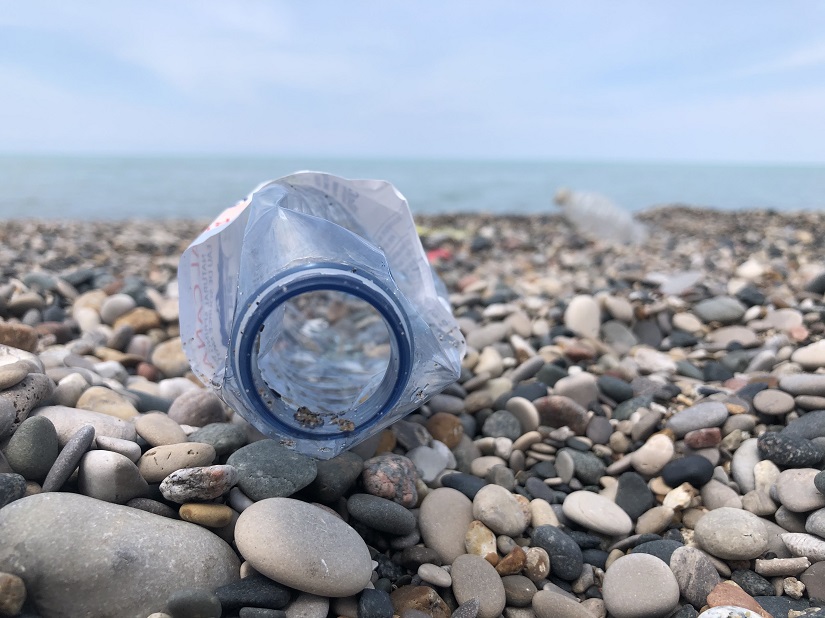 bouteille d’eau en plastique sur le sol d’une plage