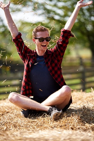 person sitting on hay bale