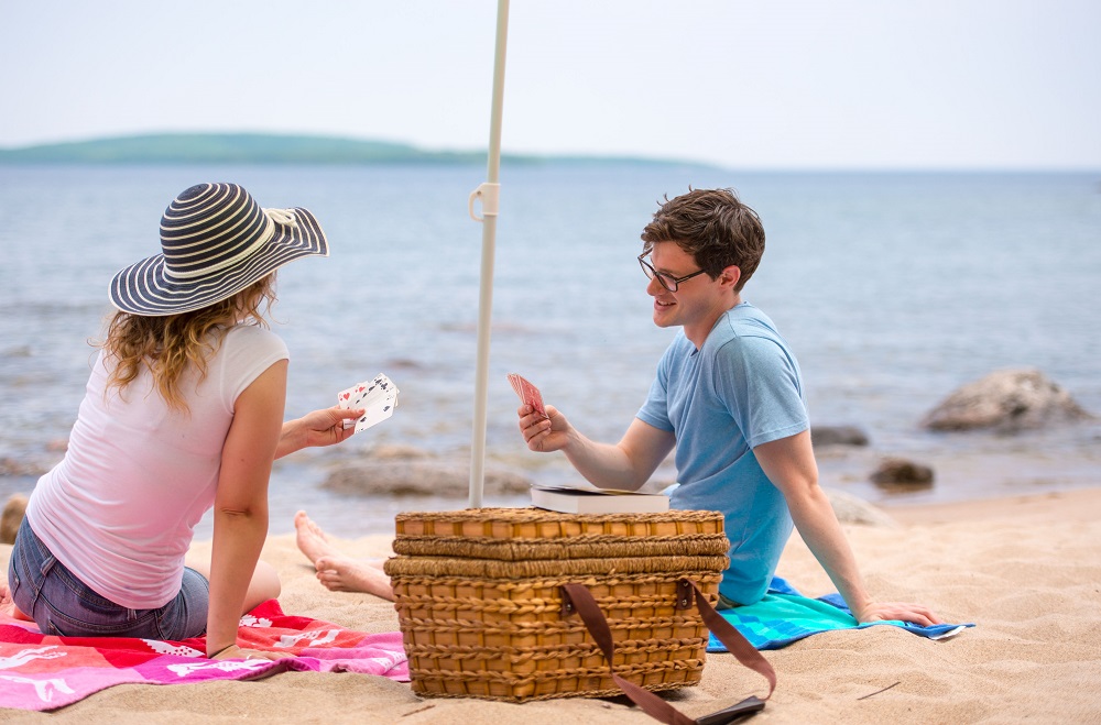two people playing cards at beach