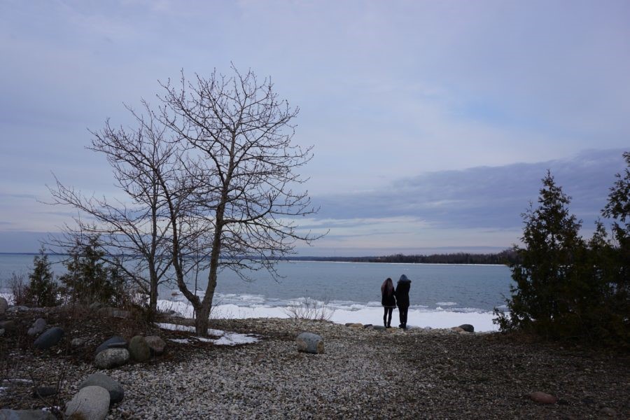 Deux personnes debout près d’une rive en hiver