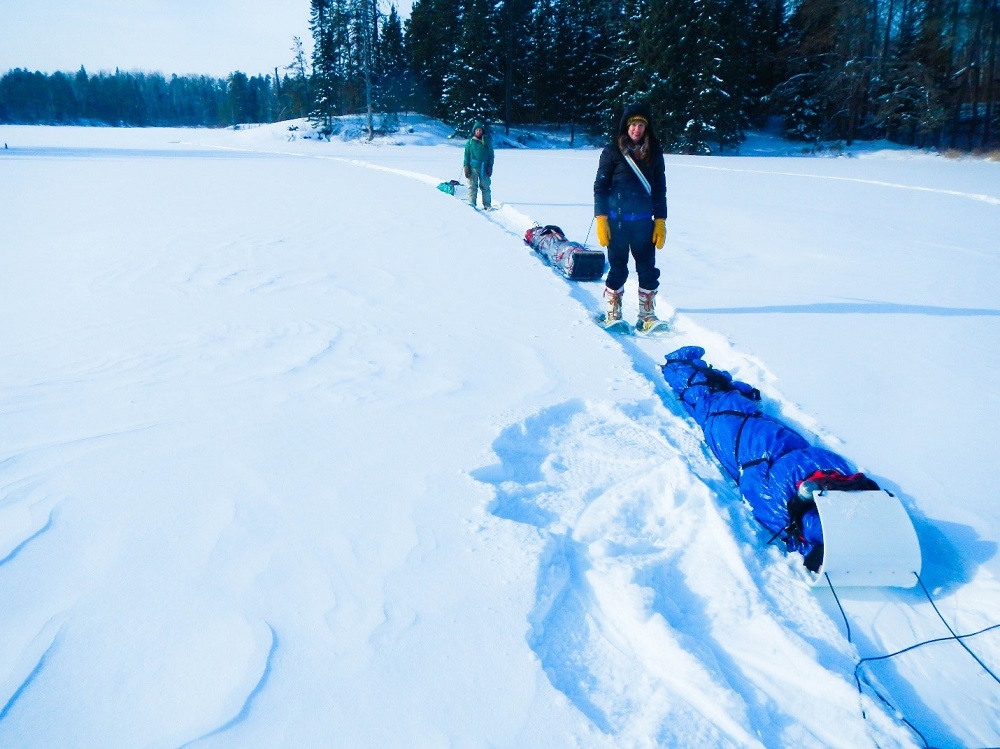 people pulling sleds over snow