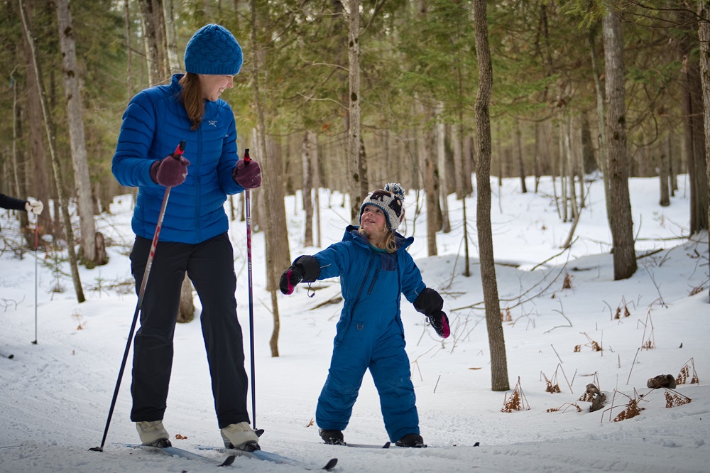 mother teaching child how to ski