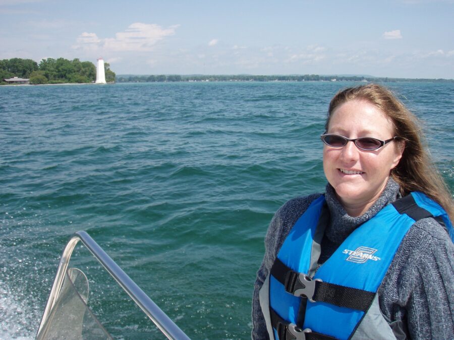 Jennifer wearing a lifejacket in a boat on Lake Ontario