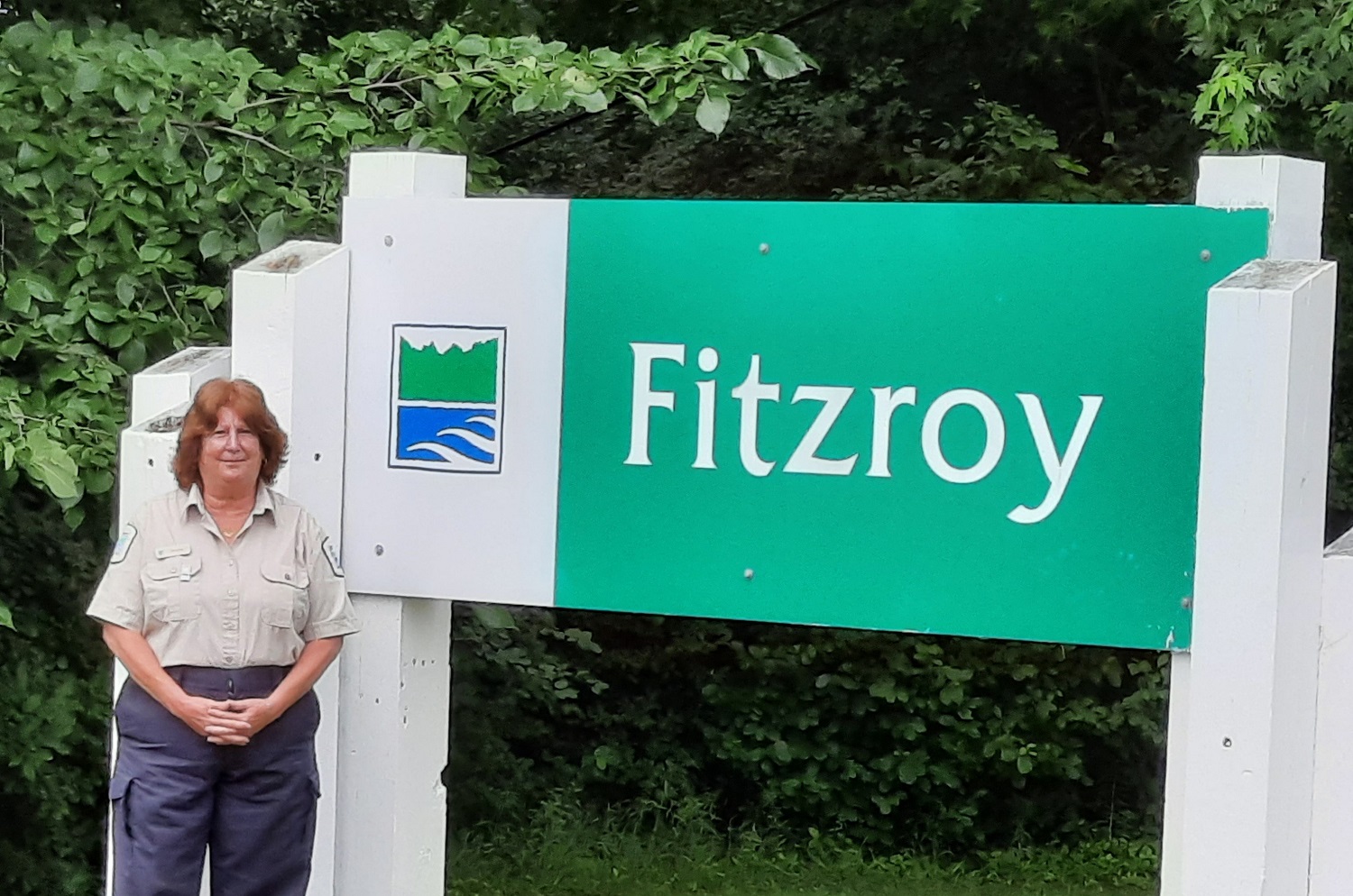 park clerk standing in front of Fitzroy entrance sign