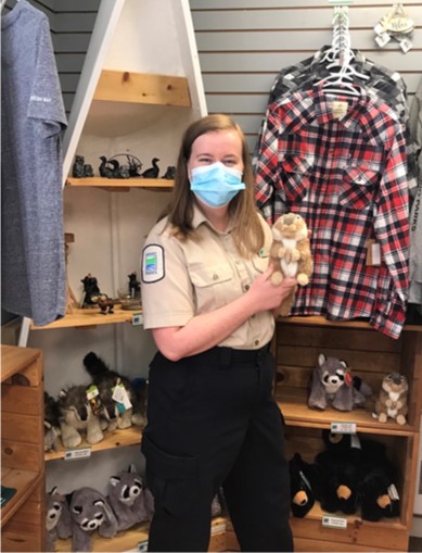 park ranger holding stuffed animal in park store