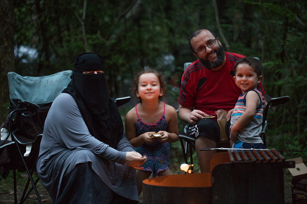 Famille assise autour d’un feu de camp.