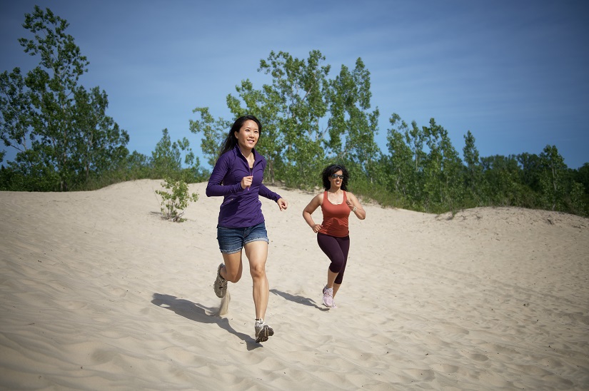 Two women running on the beach.