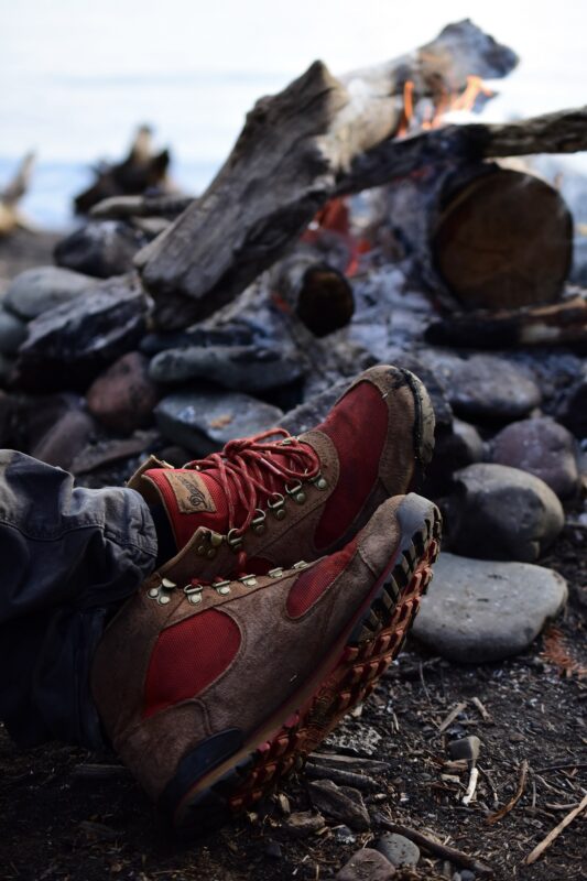 chaussures de randonnée près d’un feu