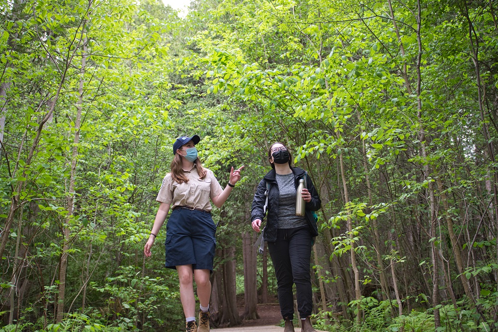 staff walking on trail with visitor
