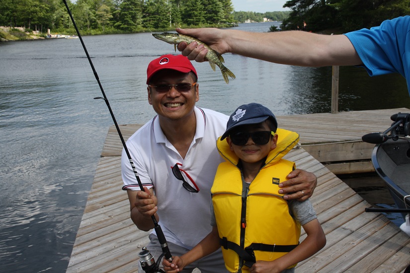 Father and son on dock fishing. 