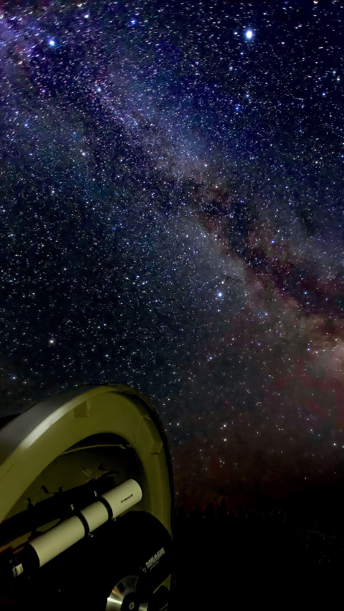 télescope au premier plan sur un fond de ciel étoilé avec la Voie lactée